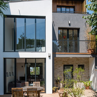 Exemple d'une façade de maison blanche tendance à deux étages et plus et de taille moyenne avec un revêtement mixte et un toit plat.