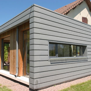 Cette image montre une petit façade métallique grise design de plain-pied avec un toit plat.