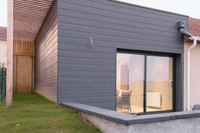Cette image montre une petite façade de maison grise design de plain-pied avec un toit plat.