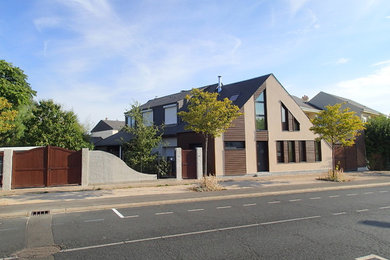 Cette image montre une petite façade de maison design en bois à deux étages et plus avec un toit à deux pans.