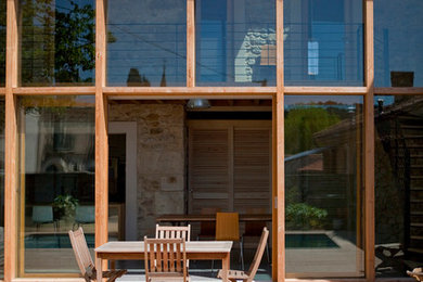Ispirazione per la facciata di una casa marrone contemporanea a due piani di medie dimensioni con rivestimento in vetro e tetto a capanna