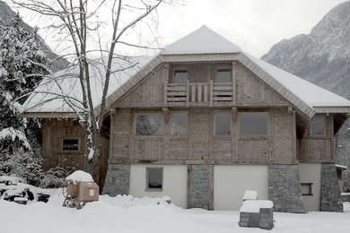 Cette image montre une petite façade de maison chalet en bois à deux étages et plus.