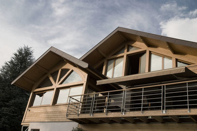 Cette image montre une façade de maison marron chalet en bois de taille moyenne et à deux étages et plus avec un toit à deux pans.