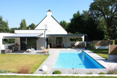 Cette photo montre une façade de maison blanche tendance de taille moyenne avec un toit à deux pans.