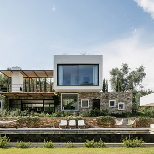 Cette photo montre une grand façade de maison multicolore tendance à un étage avec un revêtement en stuc et un toit plat.