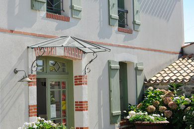 This is an example of a white and medium sized classic two floor house exterior in Paris with a pitched roof.