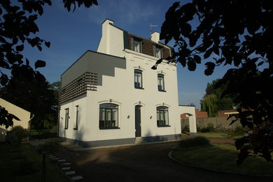 Exemple d'une grande façade de maison blanche éclectique en bois à deux étages et plus avec un toit à deux pans.