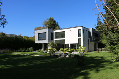 Exemple d'une grande façade de maison blanche moderne en panneau de béton fibré à un étage avec un toit plat.