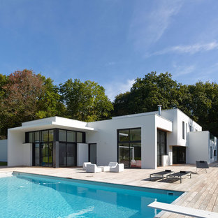 Idées déco pour une façade de maison blanche contemporaine de plain-pied avec un revêtement en stuc et un toit plat.