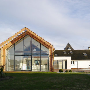 Aménagement d'une façade de maison blanche contemporaine avec un revêtement mixte et un toit à deux pans.