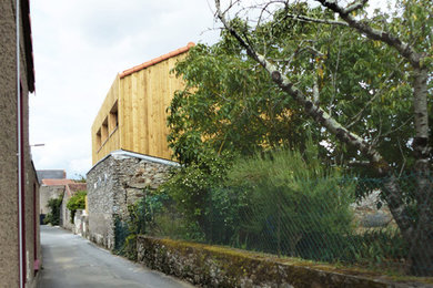 Diseño de fachada de casa actual de dos plantas con revestimiento de madera, tejado a dos aguas y tejado de teja de barro