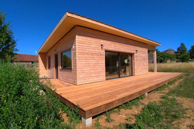 Foto de fachada contemporánea de tamaño medio de una planta con revestimiento de madera, tejado de un solo tendido y tejado de metal