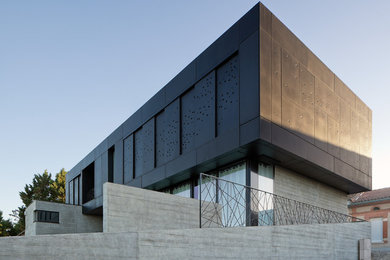 Idées déco pour une façade de maison noire contemporaine à un étage avec un revêtement mixte et un toit plat.