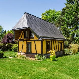 Exemple d'une petit façade de maison jaune chic à un étage avec un revêtement en adobe et un toit à croupette.