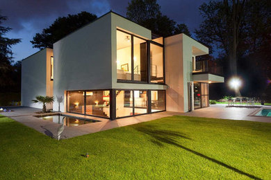 Inspiration pour une grande façade de maison blanche minimaliste à un étage avec un toit plat.