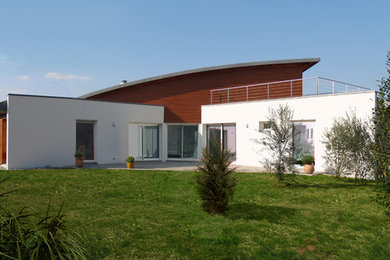 Inspiration pour une très grande façade de maison blanche minimaliste en béton à deux étages et plus avec un toit plat.