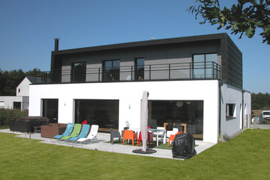 Inspiration pour une grande façade de maison minimaliste à un étage avec un toit plat.