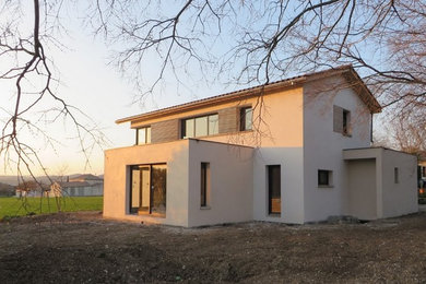 Idées déco pour une façade de maison blanche contemporaine en brique de taille moyenne et à un étage avec un toit à deux pans.