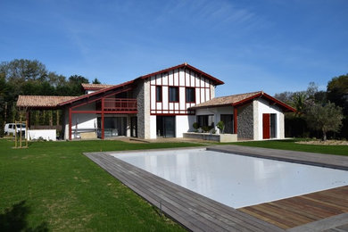 Immagine della villa grande bianca classica a due piani con rivestimento in cemento e copertura in tegole