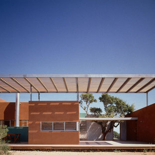Inspiration pour une façade de maison rouge méditerranéenne de taille moyenne et de plain-pied avec un revêtement mixte et un toit plat.