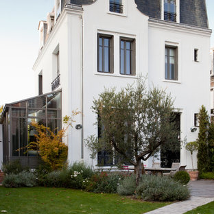 Inspiration pour une grand façade de maison blanche traditionnelle à deux étages et plus avec un toit à quatre pans.