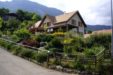 Imagen de fachada de casa blanca rural de dos plantas con tejado a doble faldón y tejado de teja de barro