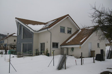 Ejemplo de fachada de casa gris rústica grande de una planta con revestimiento de madera, tejado a doble faldón y tejado de teja de barro