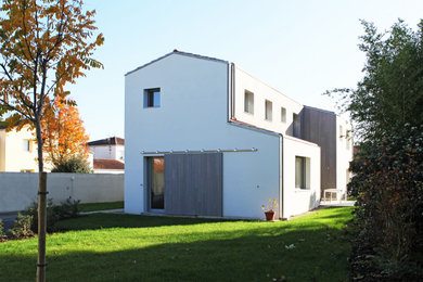 Exemple d'une façade de maison grise moderne en bois de taille moyenne et à un étage avec un toit à deux pans et un toit en tuile.