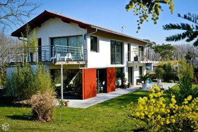 Стильный дизайн: большой, двухэтажный, белый частный загородный дом в современном стиле с облицовкой из бетона, двускатной крышей и черепичной крышей - последний тренд