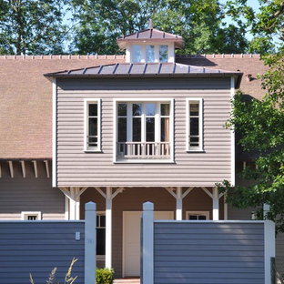 Réalisation d'une très grand façade de maison grise craftsman à un étage avec un toit à deux pans et un toit en tuile.