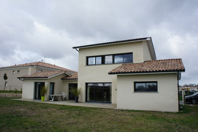 Cette photo montre une façade de maison blanche tendance en brique de taille moyenne et à un étage avec un toit à deux pans.