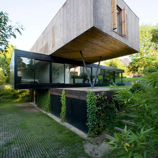 Foto della facciata di una casa contemporanea a tre piani con rivestimento in legno e tetto piano