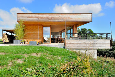 Foto de fachada marrón contemporánea de tamaño medio de una planta con revestimiento de madera y tejado plano