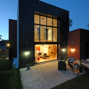 Cette image montre une façade de maison grise design de taille moyenne et à un étage avec un toit plat.
