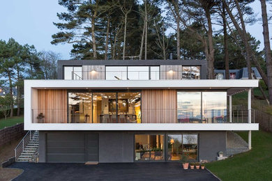 Стильный дизайн: большой, трехэтажный, коричневый дом в стиле модернизм с комбинированной облицовкой и плоской крышей - последний тренд