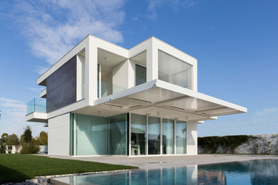 Cette image montre une grande façade de maison blanche design avec un revêtement mixte et un toit plat.