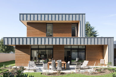 Exemple d'une façade de maison marron tendance en bois avec un toit plat.