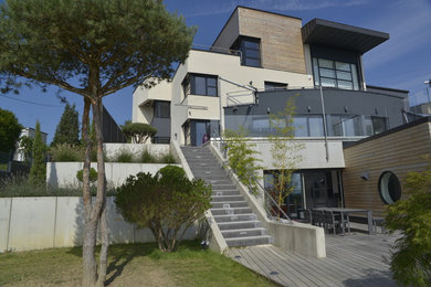 Exemple d'une très grande façade de maison grise tendance à deux étages et plus avec un revêtement mixte et un toit plat.
