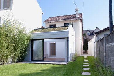 Cette photo montre une façade de maison blanche tendance en béton à un étage.