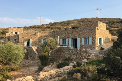 Cette image montre une très grande façade de maison beige méditerranéenne en pierre de plain-pied.