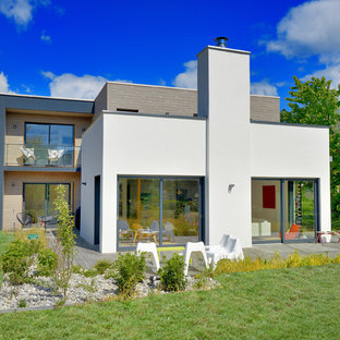 Idée de décoration pour une façade de maison blanche design à un étage avec un toit plat.