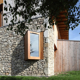 Cette image montre une façade de maison beige design de taille moyenne et à un étage avec un revêtement mixte et un toit plat.