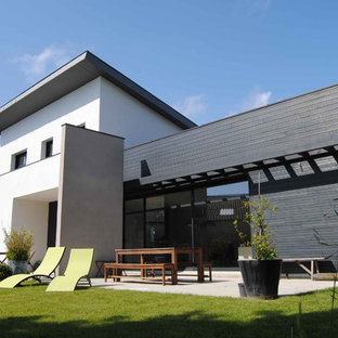 Cette photo montre une grand façade de maison blanche tendance à un étage avec un toit plat.