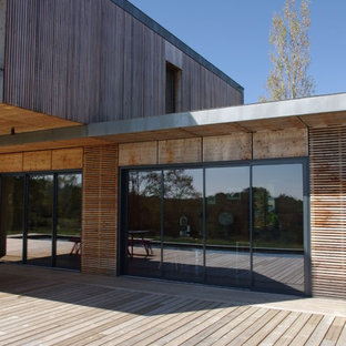 Aménagement d'une façade en bois marron contemporaine de taille moyenne et à un étage avec un toit plat.