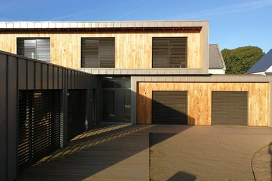 Inspiration pour une grande façade de maison marron design à un étage avec un revêtement mixte, un toit plat et un toit végétal.