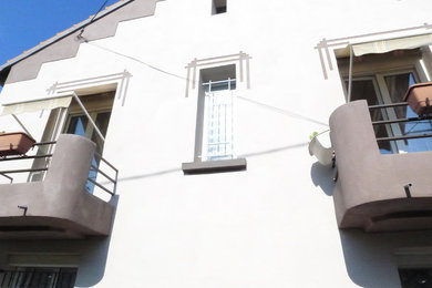 Modelo de fachada de casa pareada beige actual de dos plantas con revestimiento de hormigón, tejado a dos aguas y tejado de teja de barro