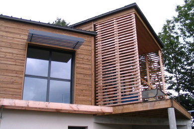 Diseño de fachada de casa blanca actual de tres plantas con revestimiento de madera y tejado de metal