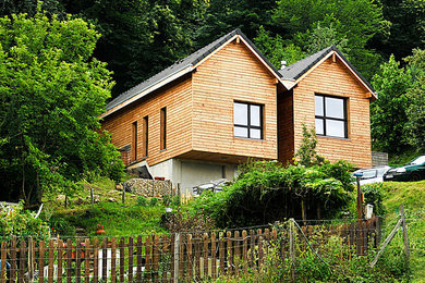 Exemple d'une façade de maison marron montagne en bois de taille moyenne et à un étage avec un toit à deux pans.