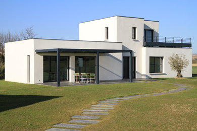 Modelo de fachada de casa blanca contemporánea pequeña de dos plantas con revestimiento de ladrillo, tejado plano y tejado de varios materiales
