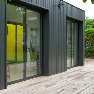 Réalisation d'une façade en bois noire design de taille moyenne et de plain-pied avec un toit plat.